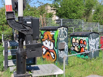 912787 Gezicht op twee relaiskasten bij de spoorwegovergang in de Huizingalaan te Utrecht, met graffiti o.a. van het ...